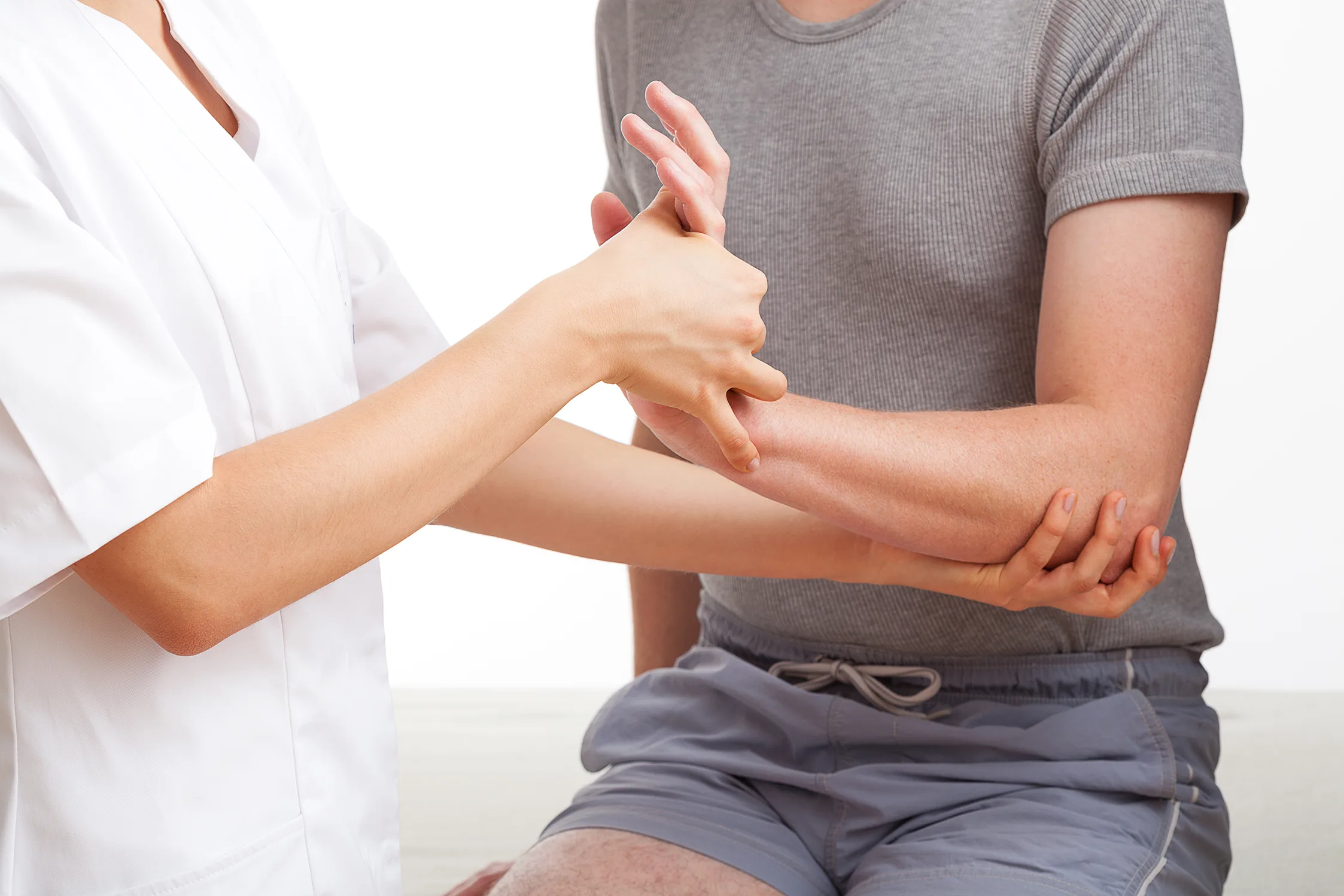 De Quervain's Tenosynovitis - A man's forearm being assessed by a doctor