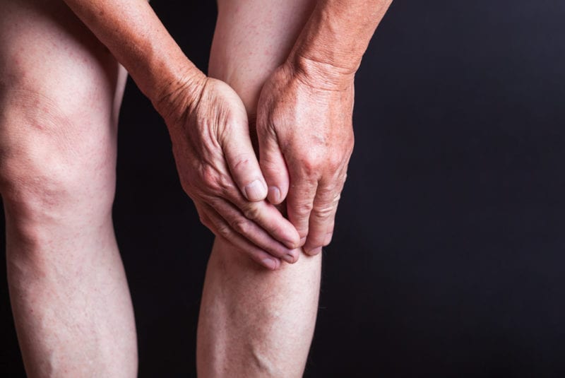How many steroid injections - An elderly man or woman holding their left knee. Close up, with no clothes on the legs.