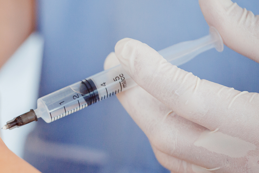 Steroid injection conditions - A close up shot of a needle with a liquid being delivered to a body part
