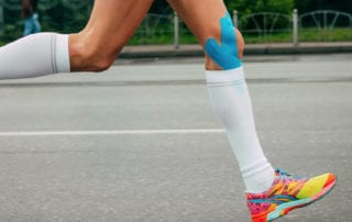 injection therapy for runners - image of a female runners legs with strapping on.