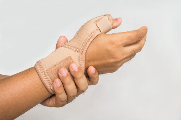 first cmc - a hand with a thumb bandage being held by another hand.